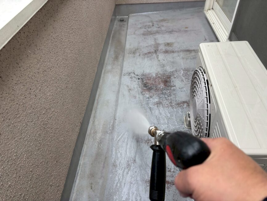 写真：ベランダ床を洗浄している様子